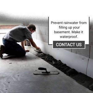 Man waterproofing a basement wall with concrete sealant