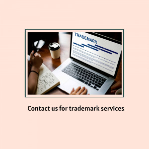 Laptop displaying trademark information with a notebook and coffee cup