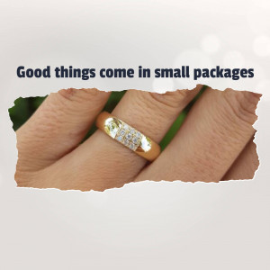 Close-up of a gold ring with diamonds on a finger