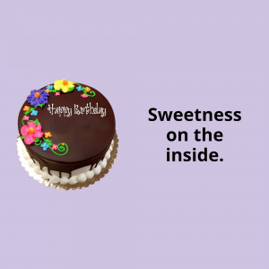 Chocolate birthday cake with flowers and the text 'Happy Birthday'