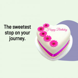 A heart-shaped birthday cake decorated with pink flowers and a 'Happy Birthday' message.