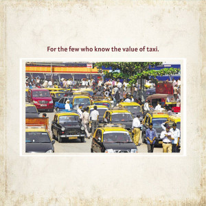 A busy street scene in Mumbai, India, filled with yellow and black taxis and pedestrians.