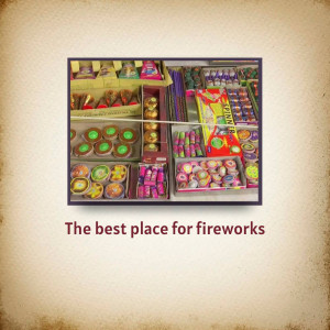 A colorful display of various types of fireworks arranged in boxes.