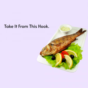 A close-up of a grilled fish served on a white rectangular plate with lemon, olives, and a side of sauce.