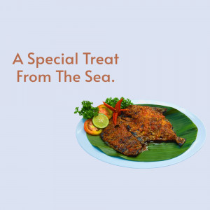 Close-up of a fried fish dish served on a banana leaf with lime, tomato, and chili garnish.