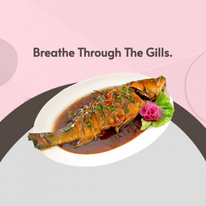 A beautifully presented steamed fish dish with a vibrant red and brown sauce, garnished with chili and herbs.