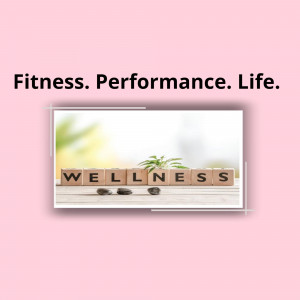 Wooden blocks spelling out 'WELLNESS' on a wooden surface, with a pink background.