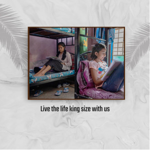 Two young girls studying on bunk beds in a hostel room.