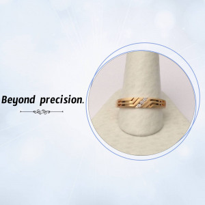 Close-up of a gold ring with diamond accents on a white display stand