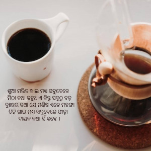 Close-up of a white coffee cup being filled with coffee from a silver pour-over set on a cork coaster.