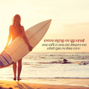 Woman holding a surfboard on a beach, facing the ocean.