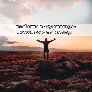 A person with arms outstretched standing on a rocky outcrop overlooking a vast landscape.