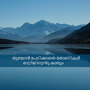 A tranquil landscape featuring a calm lake reflecting snow-capped mountains under a clear blue sky.
