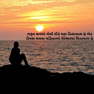 Silhouette of a person sitting by the ocean during a vibrant sunset.