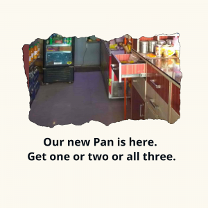 Interior view of a small pan shop with a display fridge and counter