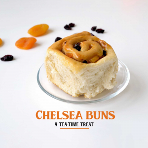 Close-up of a Chelsea bun on a glass plate with dried apricots and currants, with text 'Chelsea Buns - A Tea Time Treat'