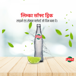 Limeca soda bottle with lime slice and green leaves on a wooden surface