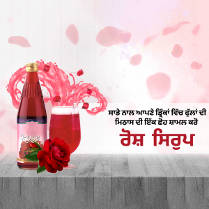 A bottle and glass of rose syrup with rose petals and flowers.