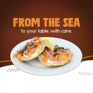 Close-up of a bagel with smoked salmon, red onion, capers, and a lemon wedge.