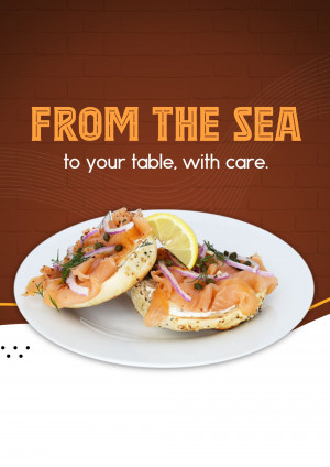 A close-up of a bagel with smoked salmon, red onion, capers, and a lemon wedge.