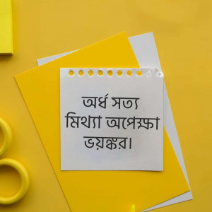 Close-up of a sticky note with Bengali text on a vibrant yellow surface.