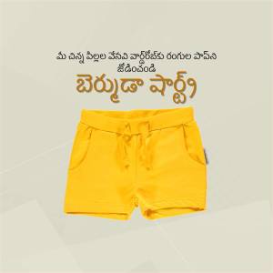 A pair of bright yellow baby shorts laid flat on a light beige background.