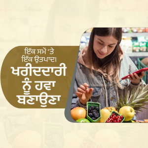 A woman with brown hair wearing a grey hoodie is looking at her phone while shopping for fruits and vegetables in a grocery store.