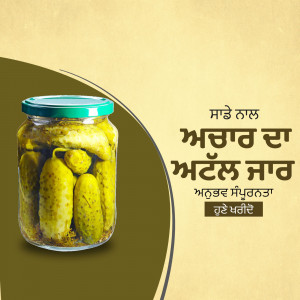 A glass jar filled with homemade pickles, with text in Punjabi.