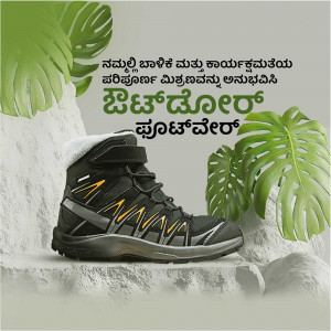 Black and grey Salomon hiking boots displayed on a rock with tropical leaves