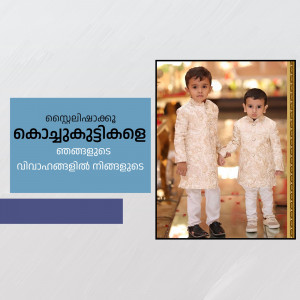 Two young boys dressed in matching traditional Indian outfits, holding hands.