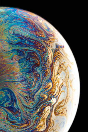 Close-up of a soap bubble showing swirling iridescent colors