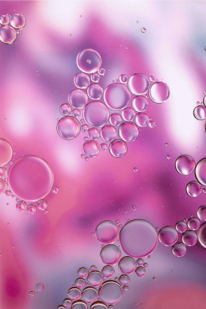 Close-up of colorful oil and water bubbles creating an abstract pattern.