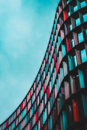 Close-up of a modern building with a curved facade featuring colorful windows