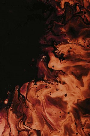 Close-up of swirling orange and brown fluid art with a dark background