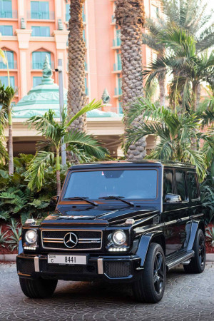Black Mercedes-Benz G-Class parked in front of a luxury hotel in Dubai