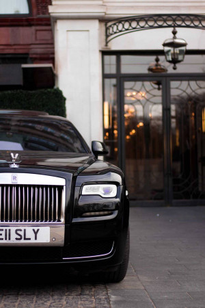 Black Rolls Royce Phantom parked in front of a building entrance