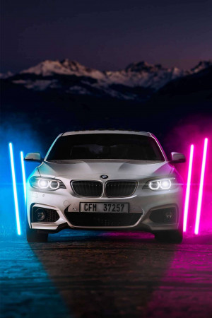 White BMW car with neon lights in the background