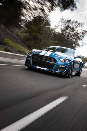 Blue Ford Mustang Shelby GT500 speeding down a highway