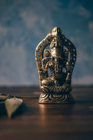 Close-up of a golden Ganesha statue with a blurred background