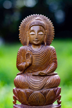 Wooden Buddha statue in a meditative pose