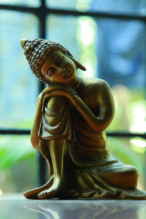 Close-up of a golden Buddha statue in a meditative pose
