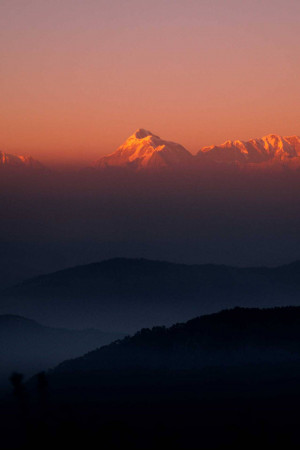 A stunning view of a mountain peak illuminated by the rising sun.