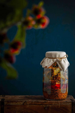 Close-up of a jar of homemade pepper jelly with a rustic aesthetic.