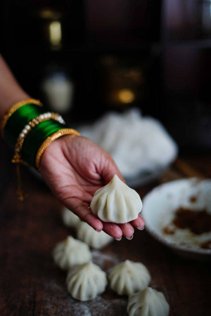 Close-up of a hand holding a Modak with other Modaks in the background