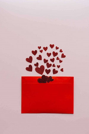 Red envelope with glitter hearts spilling out