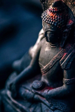 Close-up of a weathered Buddha statue in a meditative pose