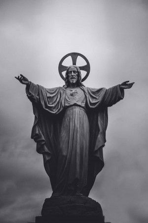 Black and white image of a statue of Jesus Christ with arms outstretched