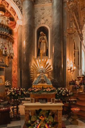 A statue of the Virgin Mary in a beautifully decorated church interior.