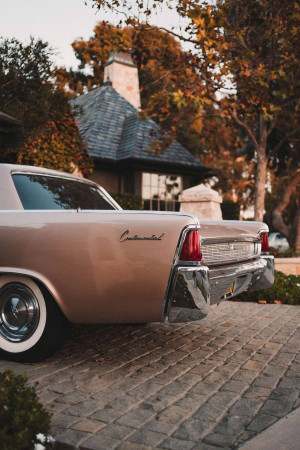 Classic pink Continental car parked in front of a house