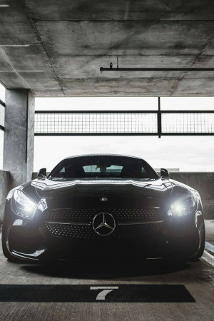 Front view of a black Mercedes-Benz AMG GT parked in a concrete parking garage.